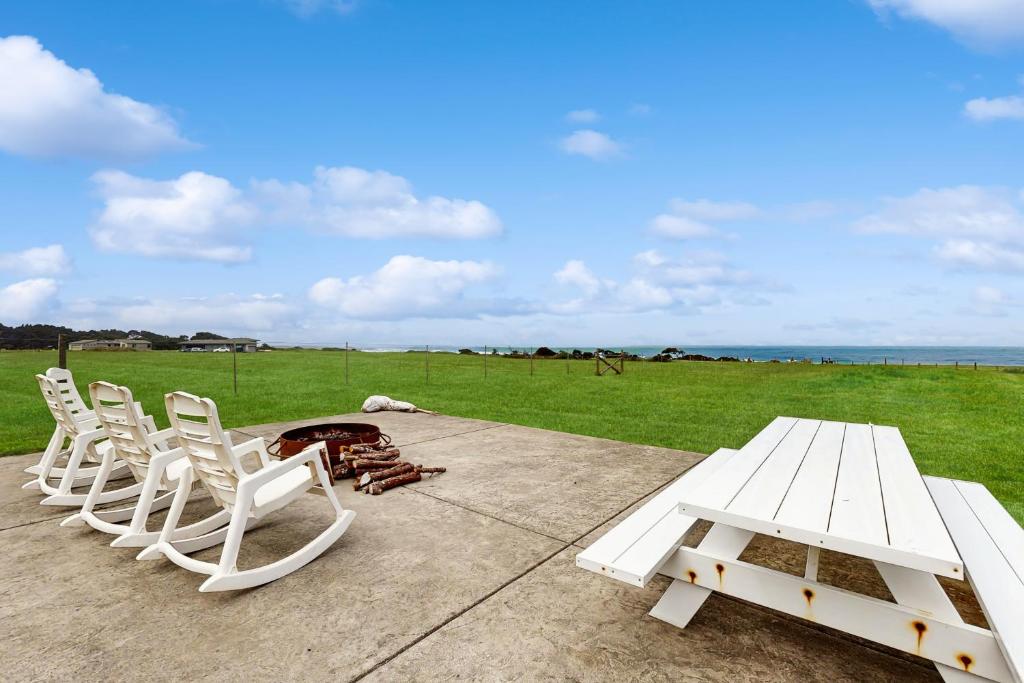 a group of white chairs and a picnic table at Stella Del Mare in Fort Bragg