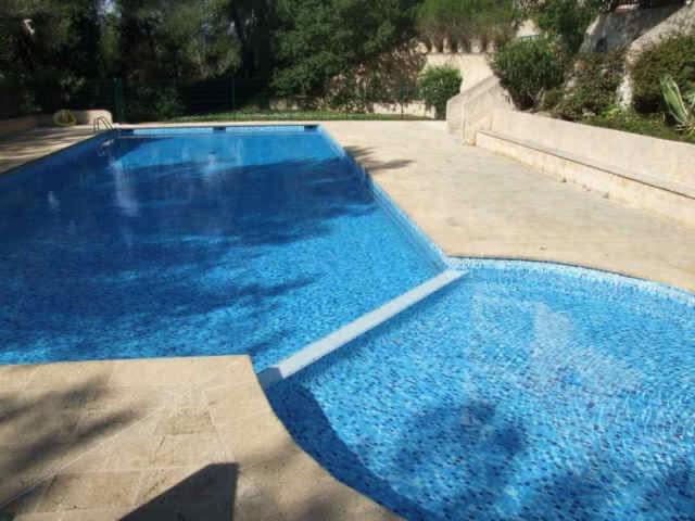 une grande piscine bleue dans une cour dans l'établissement Studio piscine parking Cannes, à Cannes
