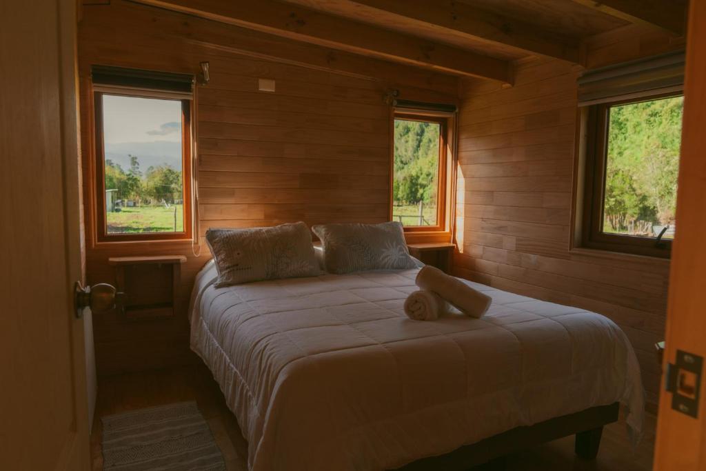 Un dormitorio con una cama con un osito de peluche. en Indómito Refugio, en Puelo