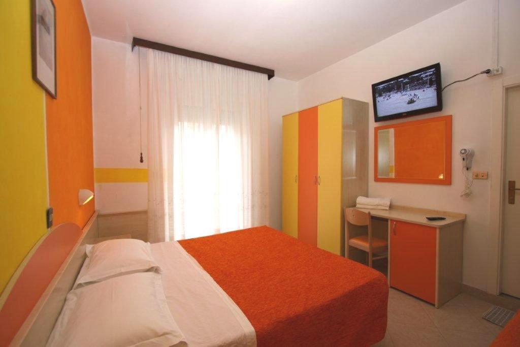 ベッラーリア・イジェア・マリーナにあるHotel Ristoroのベッドルーム(ベッド1台、デスク、テレビ付)