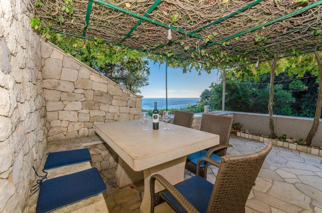 a wooden table and chairs on a patio at House ULE in Žrnovo