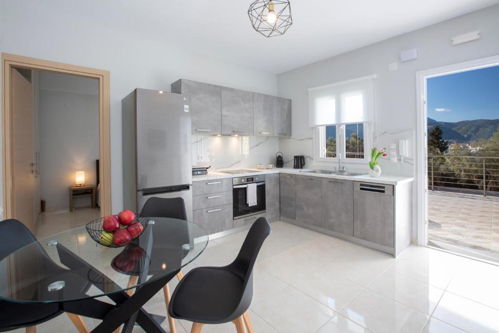 a kitchen with a glass table and black chairs at Theros Apartment 1 in Yénion