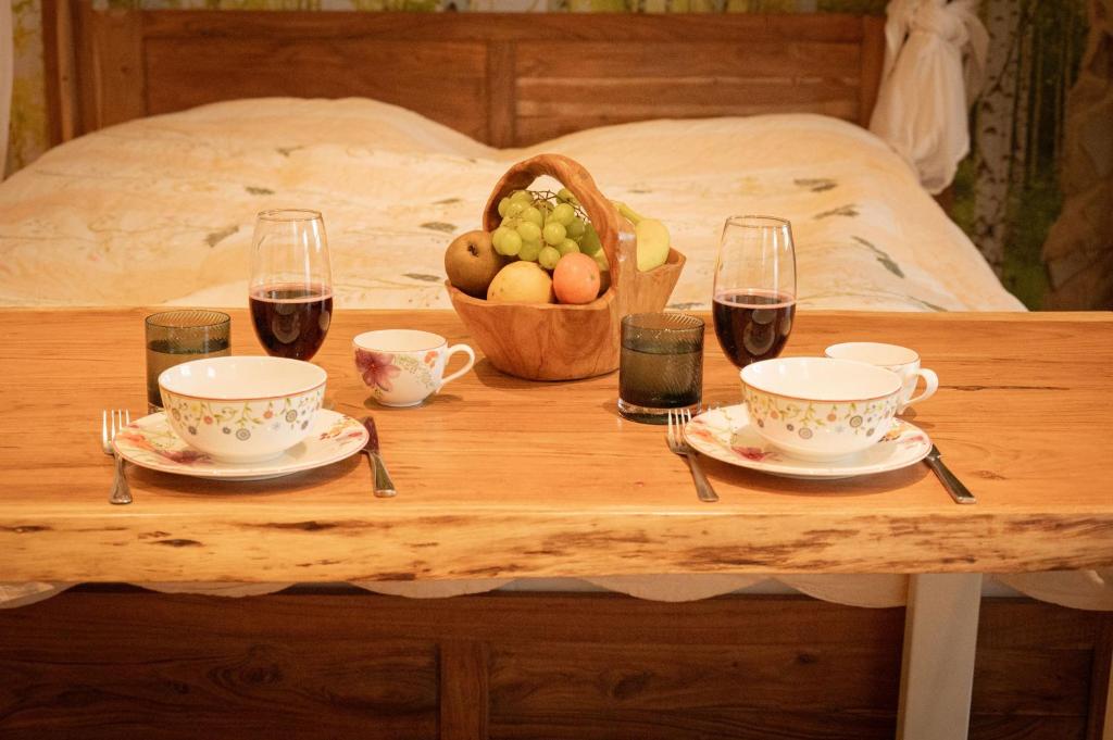 a table with two cups and a basket of fruit and wine at Saunaparadies Black Forest in Löffingen