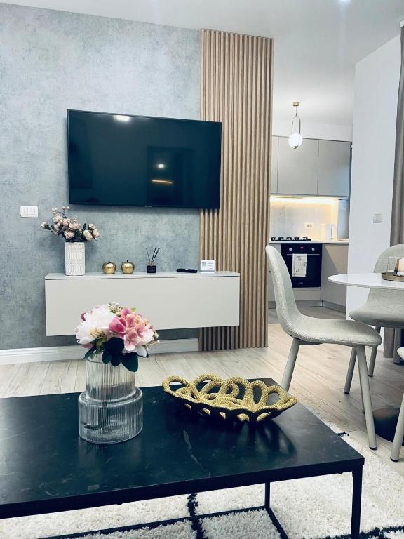 a living room with a tv and a table at City Nest Apartament in Rădăuţi