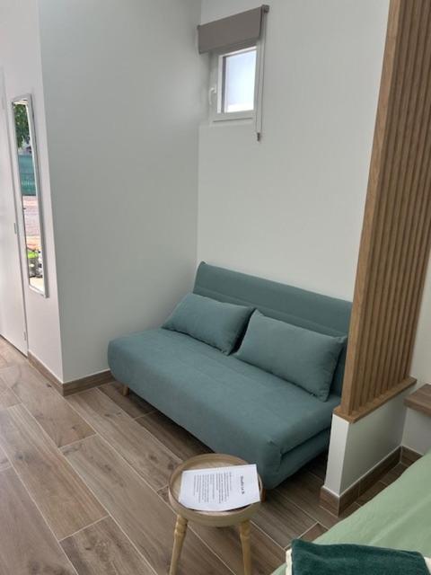 un canapé bleu dans un salon avec une table dans l'établissement Studio 36, à Saint-Romain-de-Jalionas