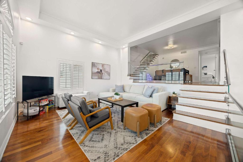 Una sala de estar con un sofá blanco y un televisor. en New Listing Dodger Clubhouse by Colby & Conrad, en Los Ángeles
