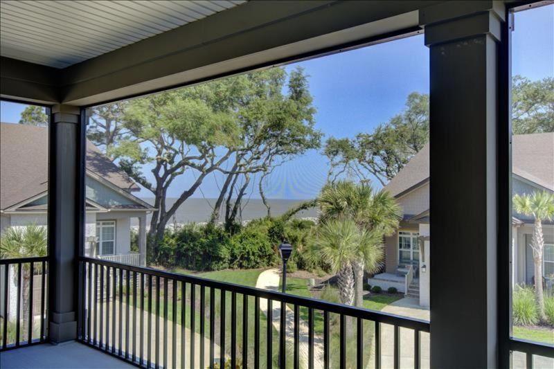 a view from the porch of a house with a balcony at Garden Cottage 08 in Jekyll Island