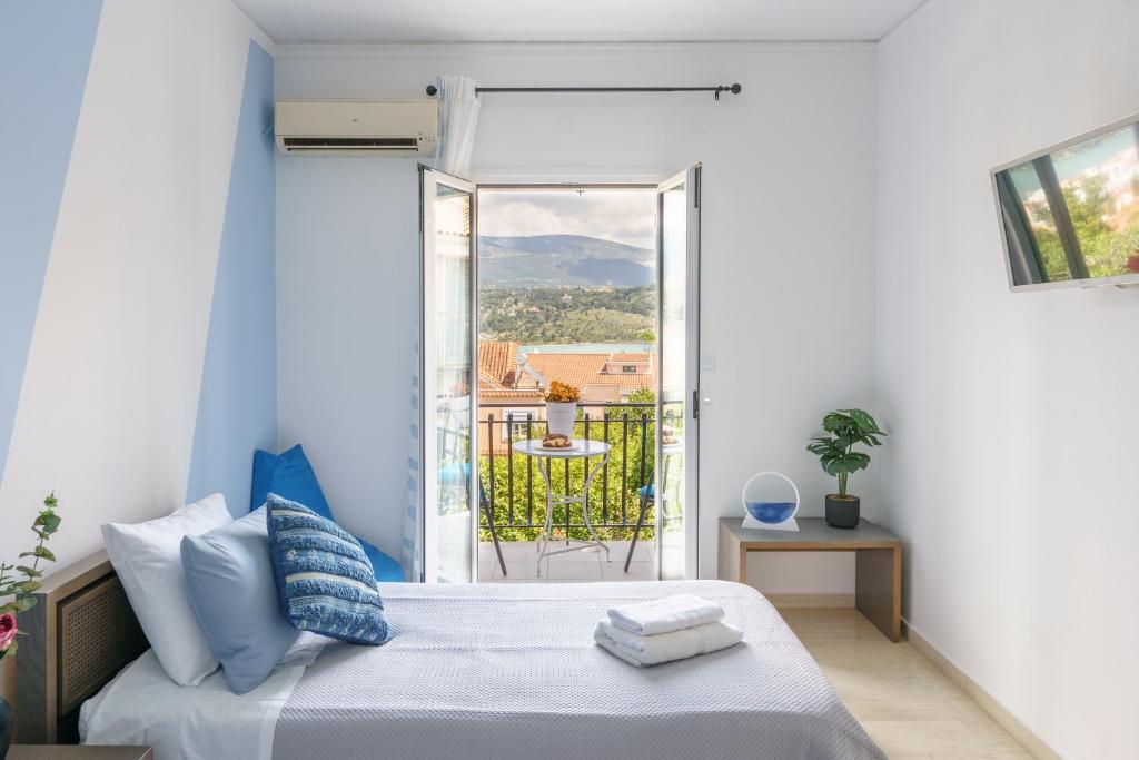 a bedroom with a bed and a view of a balcony at S K apartments K in Argostoli