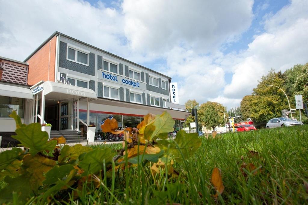 a building in the middle of a field of grass at Hotel Cockpit in Hamburg