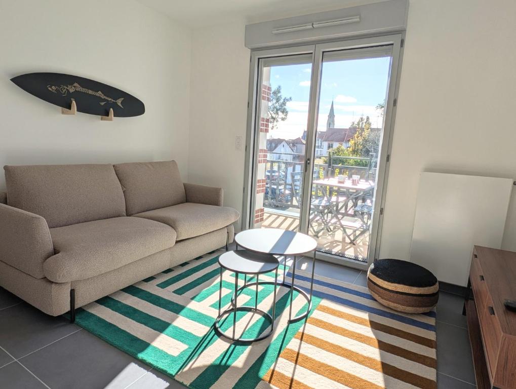 a living room with a couch and a table at Appartement lumineux avec balcon & aperçu mer in Pornic