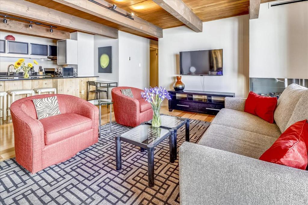 a living room with two couches and a tv at Modern Condo, 1 Block to Gondola - Ideal Vacation Location in Aspen
