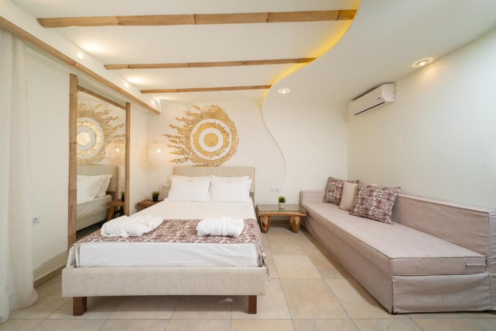 a bedroom with a bed and a couch at Ester Luxury Rooms in Skala Potamias