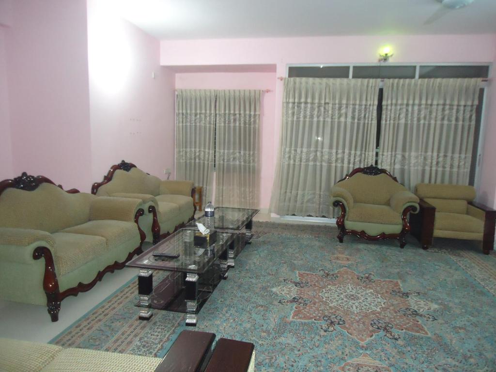 ein Wohnzimmer mit 2 Sofas und einem Tisch in der Unterkunft Unity Inn in Cox's Bazar