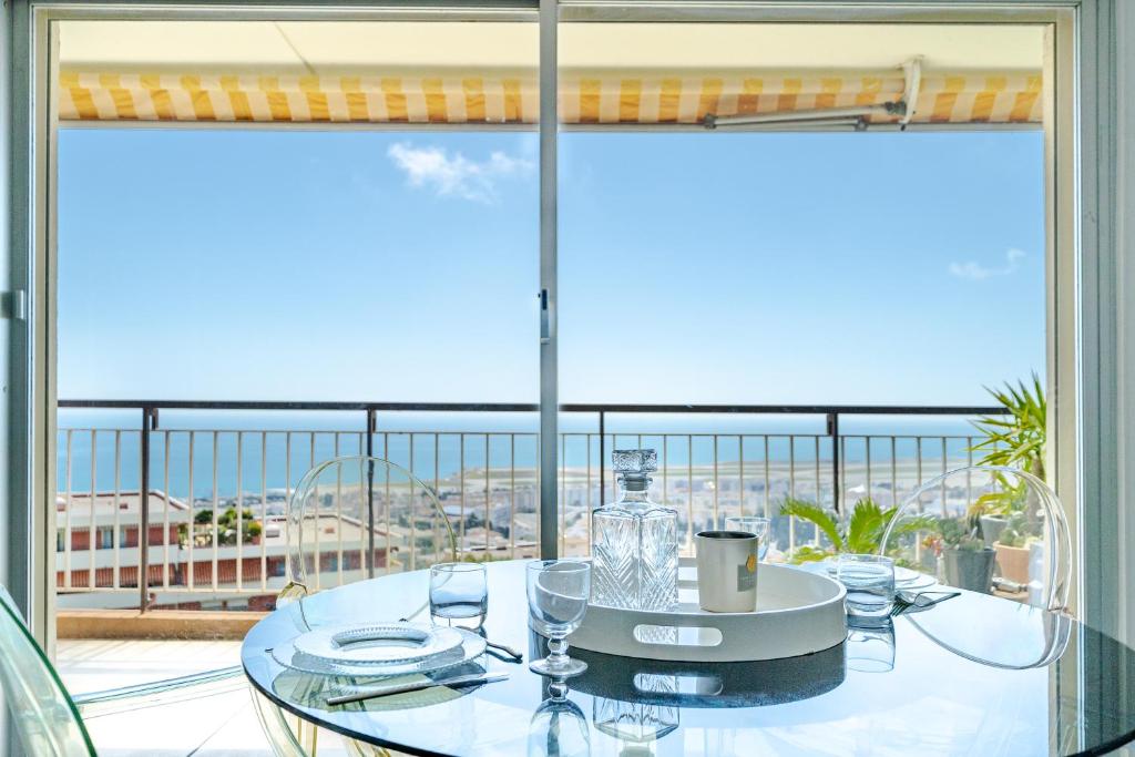 une table en verre sur un balcon avec vue dans l'établissement Studio Vue mer Parking Clim, à Nice