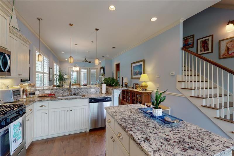 a large kitchen with white cabinets and a counter top at Garden Cottage 23 in Jekyll Island