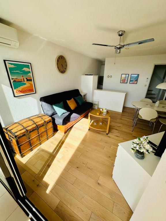 un salon avec un canapé et une table dans l'établissement Le charme de Dominica, au Barcarès