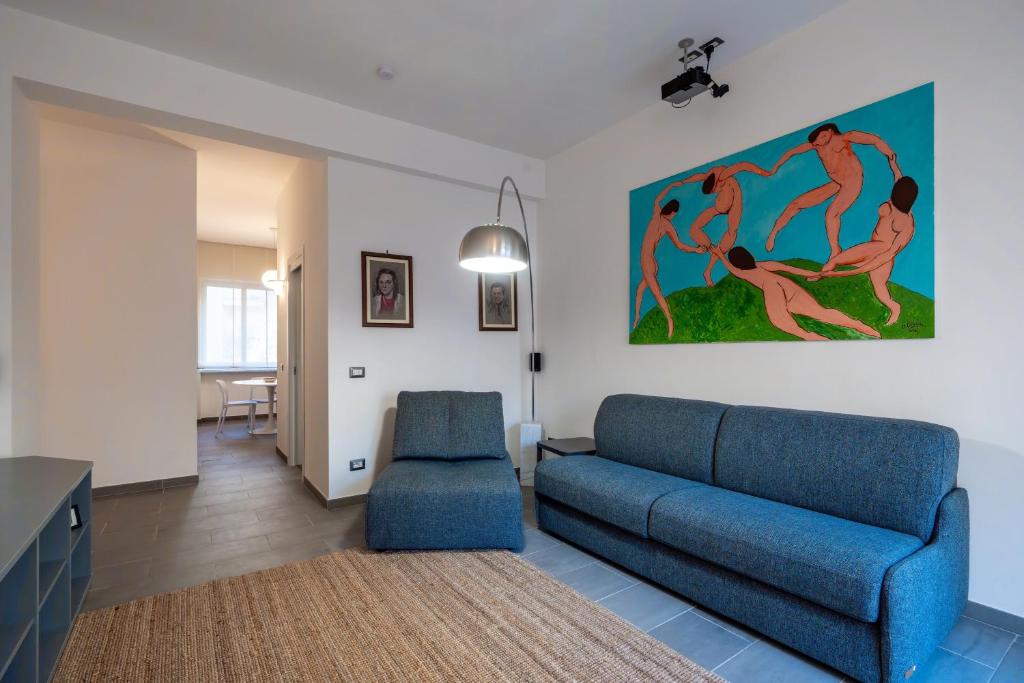un salon avec un canapé bleu et un tableau au mur dans l'établissement Pied a Terre, à Maiori