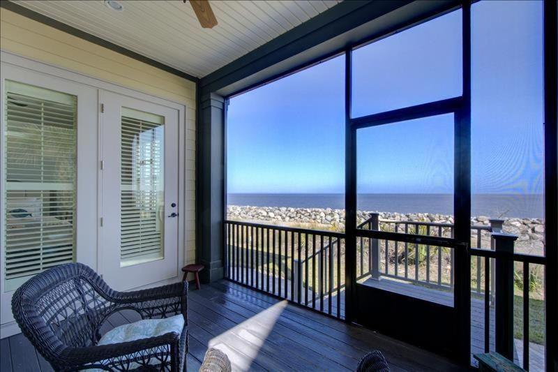 a screened in porch with a view of the ocean at Ocean Cottage 44 in Jekyll Island