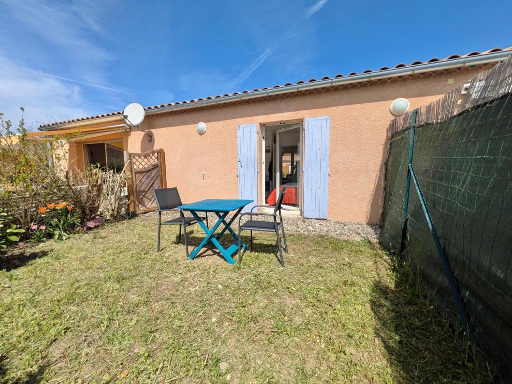 une table et des chaises devant une maison dans l'établissement Les Jardins de Montéglin - F2 avec jardin, à Montéglin
