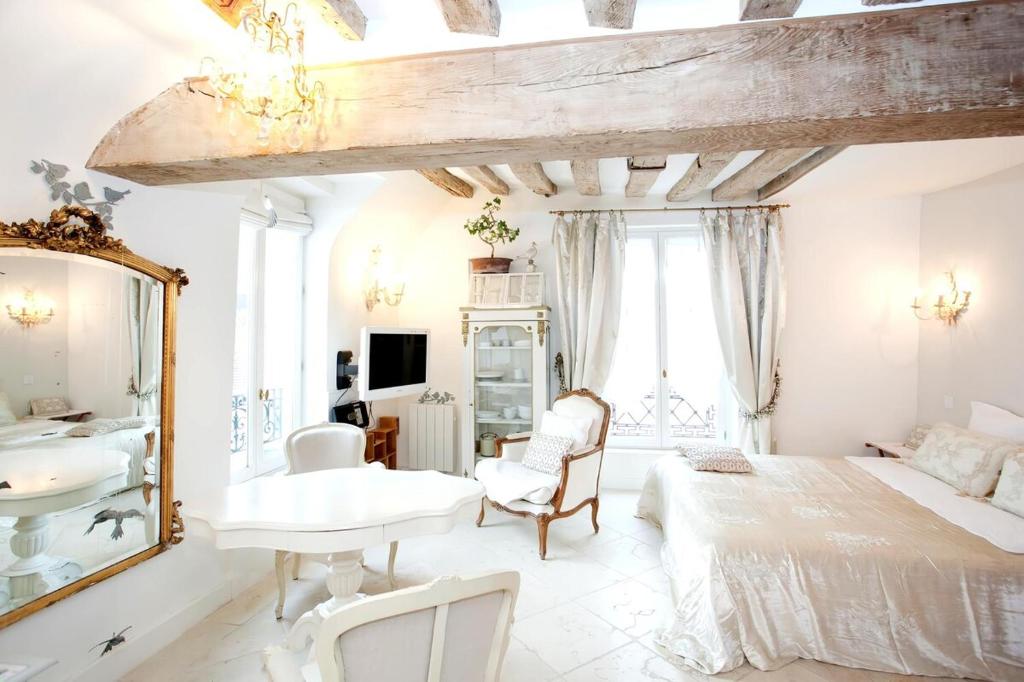 une chambre avec un lit, un lavabo et un miroir dans l'établissement Les heures parisiennes, à Paris