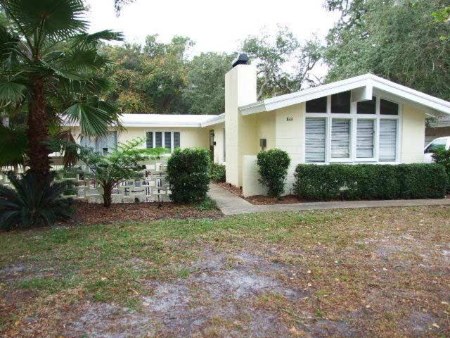 ein weißes Haus mit einer Palme davor in der Unterkunft Beachcomber Cottage in Jekyll Island