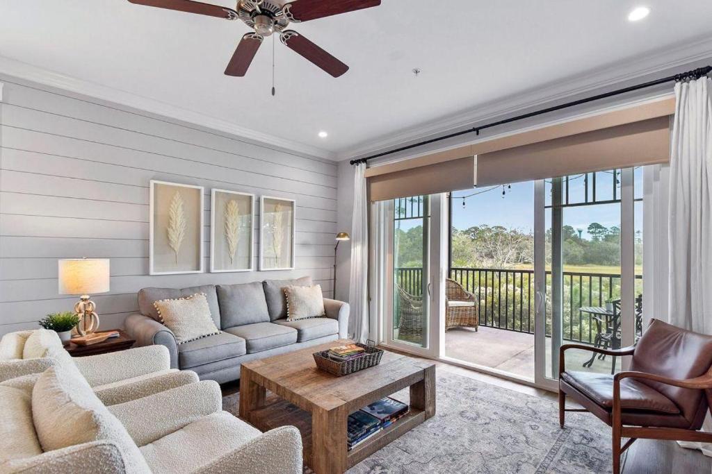 a living room with a couch and a table at Moorings 104 in Jekyll Island