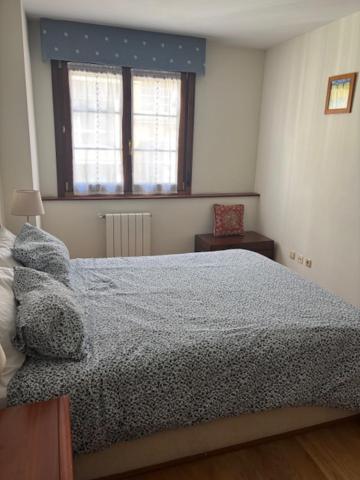 a bedroom with a large bed and a window at Living Gijon & Parking in Gijón