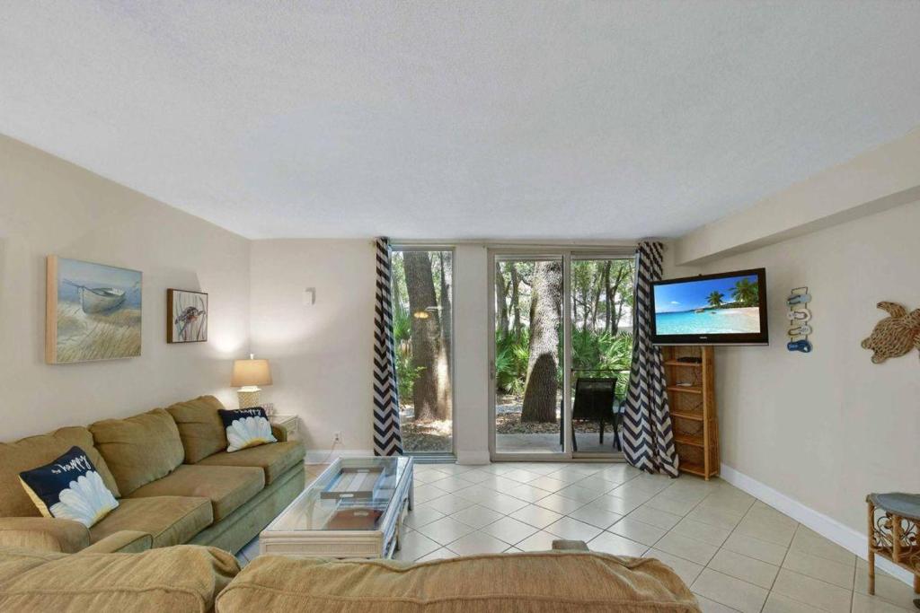 a living room with a couch and a flat screen tv at Villa 453 in Jekyll Island