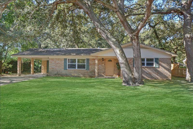 a brick house with a tree in a yard at Perry's Manor in Jekyll Island