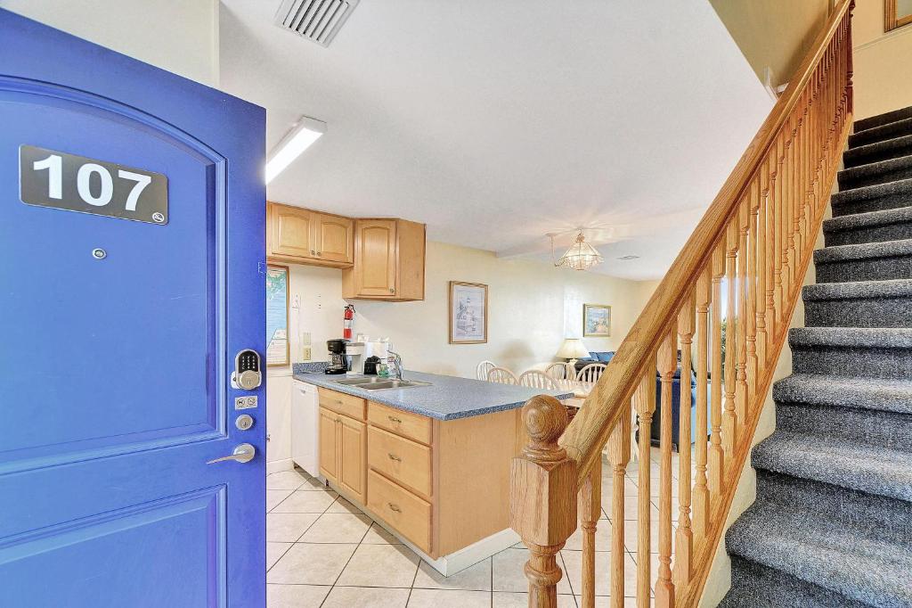 a kitchen with a blue door and a staircase at Villa 107 in Jekyll Island