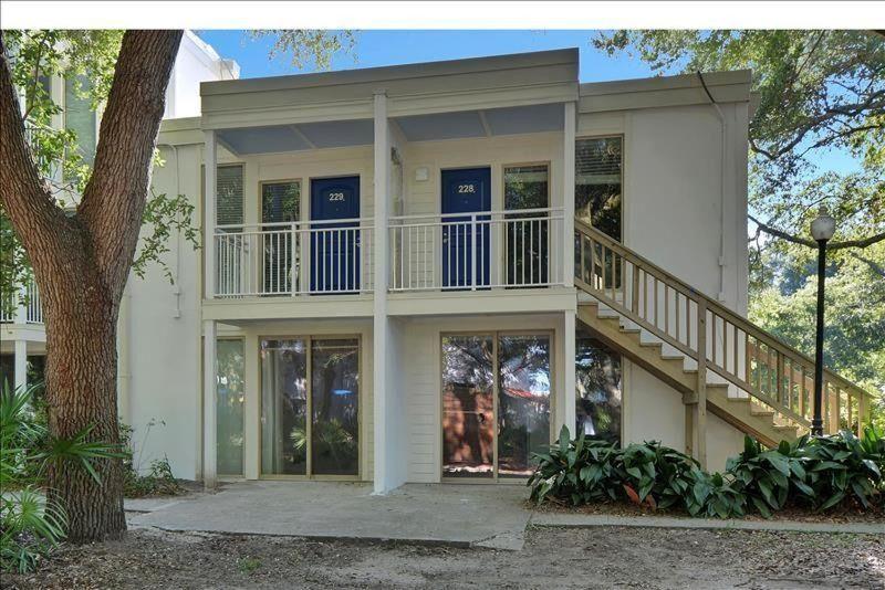 a large white house with a balcony and staircase at Villa 229 in Jekyll Island