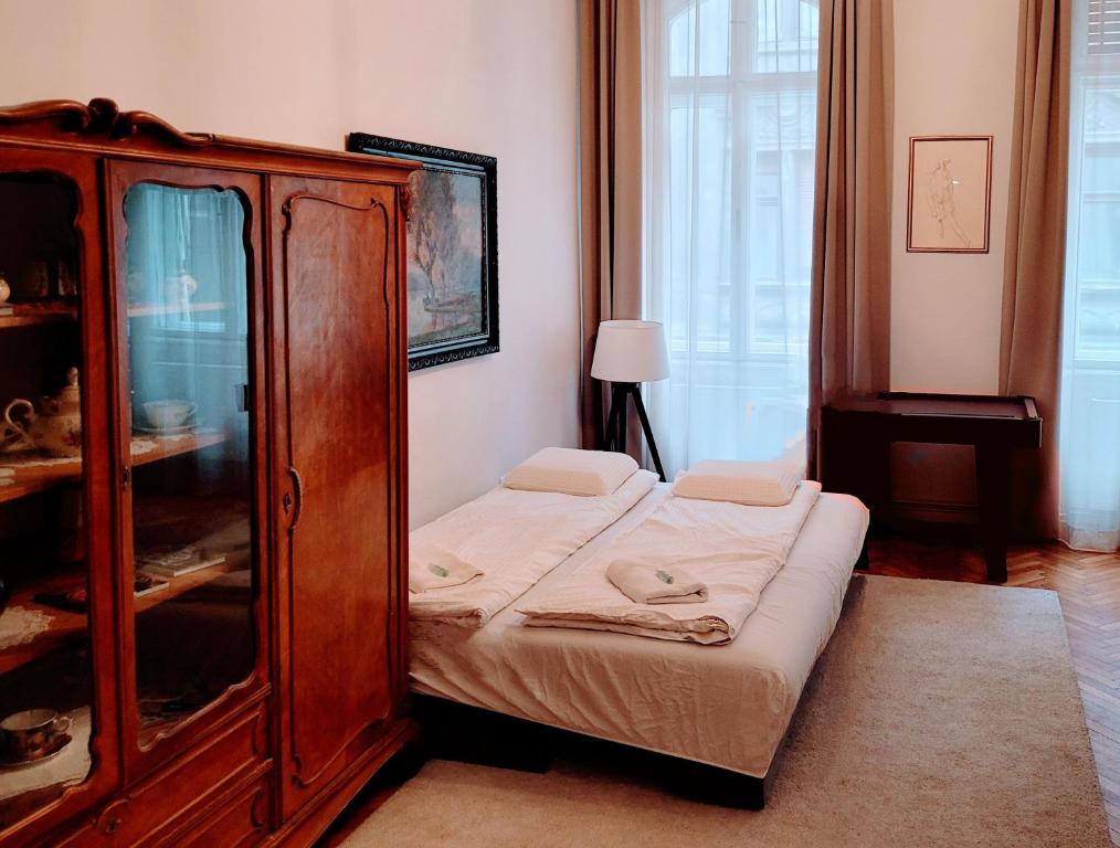 a bedroom with a wooden cabinet and a bed at Christoph's Central Apartment in Budapest