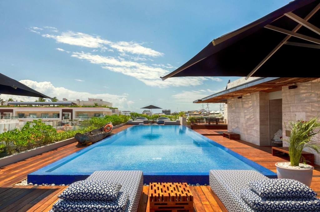 普拉亚卡门The Yucatan Playa Del Carmen, Tapestry Collection By Hilton的建筑物屋顶上的游泳池
