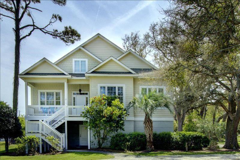 a white house with a white porch and trees at Spectacular Sunrise in Jekyll Island