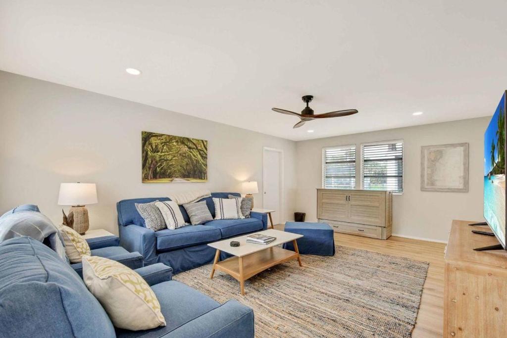 a living room with a blue couch and a table at Spring Cottage in Jekyll Island