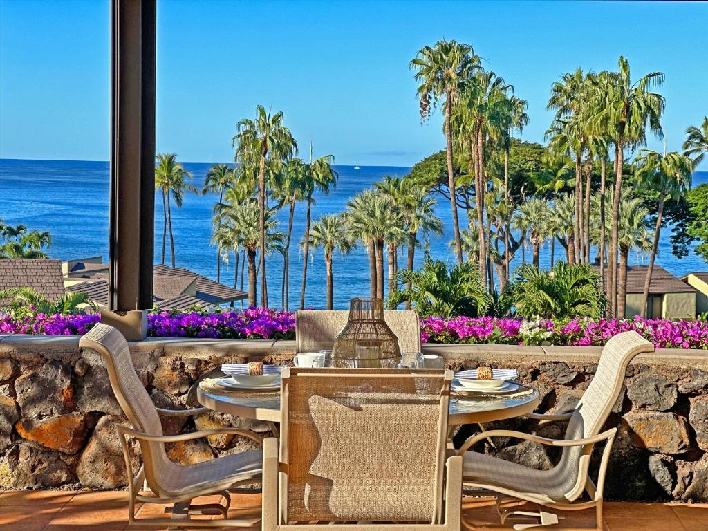 a patio with a table and chairs and the ocean at Panoramic Ocean Views! Remodeledredecorated! Very Pretty Corner Ground Floor 2 Bedroom2 Bath in Wailea