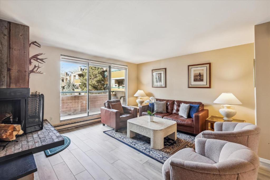 a living room with couches and a fireplace at Riverside Condo, with a Pool & Hot Tub - Steps to Town in Aspen