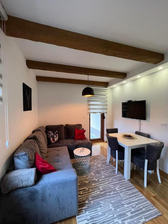 a living room with a couch and a table at Dolce apartman Zlatibor in Zlatibor