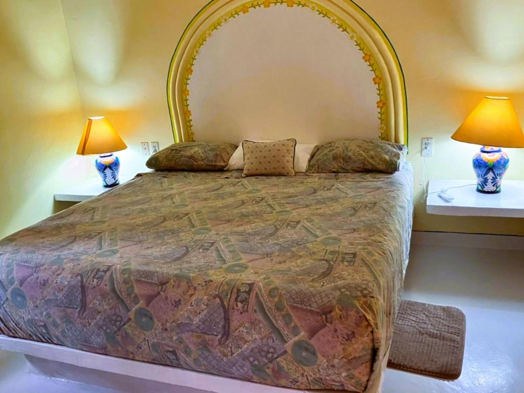 une chambre avec un grand lit avec deux lampes dans l'établissement Bungalow Tranquilidad 2, à La Manzanilla