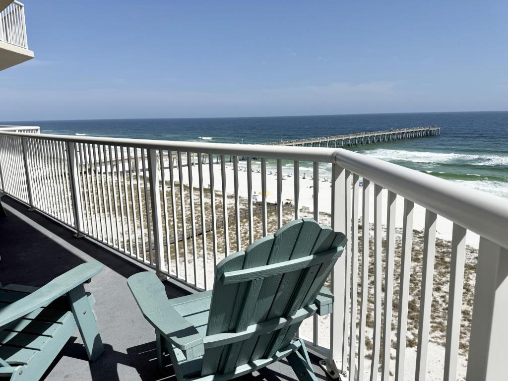 a green chair sitting on a balcony overlooking the ocean at Sea Esta condo in Navarre
