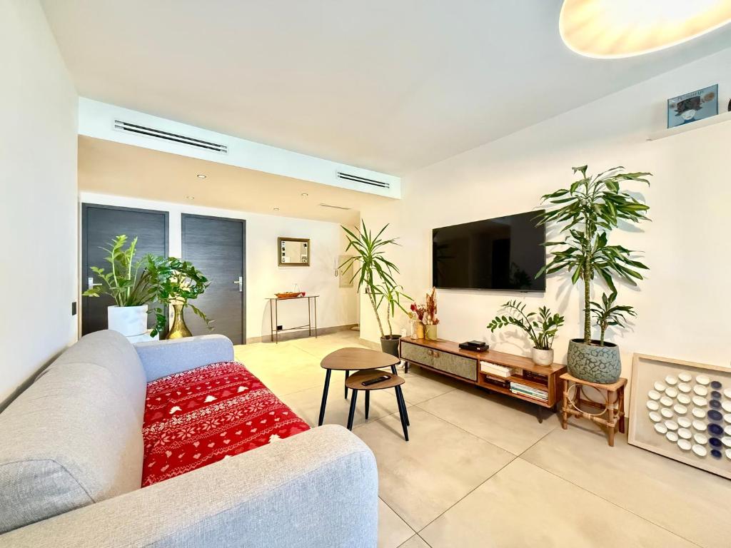 un salon avec un canapé et une télévision à écran plat dans l'établissement Splendide Appartement - Vue Mer - Cannes à 5 min, à Vallauris
