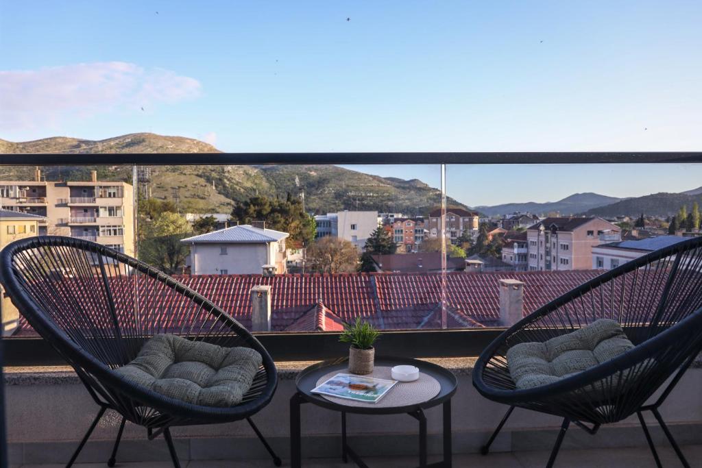 two chairs and a table on a balcony with a view at Central Rooftop Apartment in Trebinje