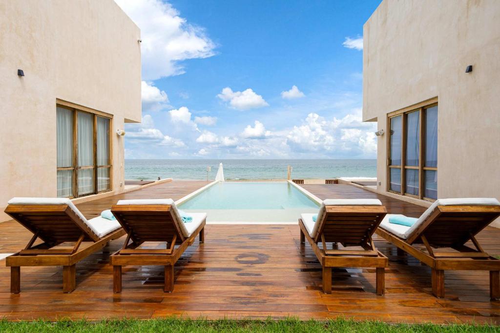 a patio with two chairs and a swimming pool at Beachfront Villa Punta Mita Litibu in Higuera Blanca