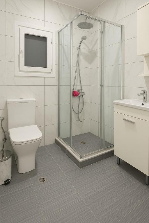łazienka z prysznicem, toaletą i umywalką w obiekcie Johns villa w mieście Artemida