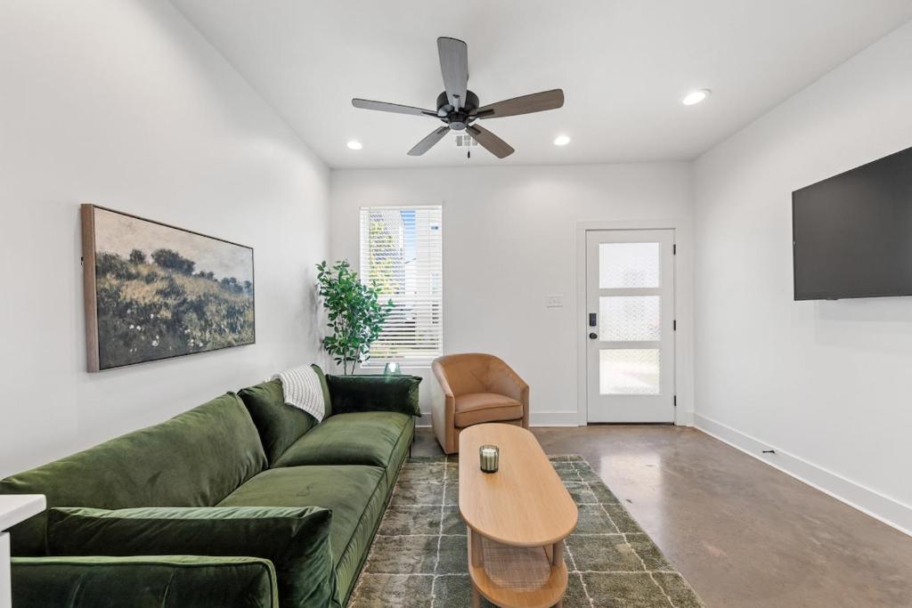 sala de estar con sofá verde y ventilador de techo en Boudin House Luxury Amenities Prime Location WiFi, en Lafayette