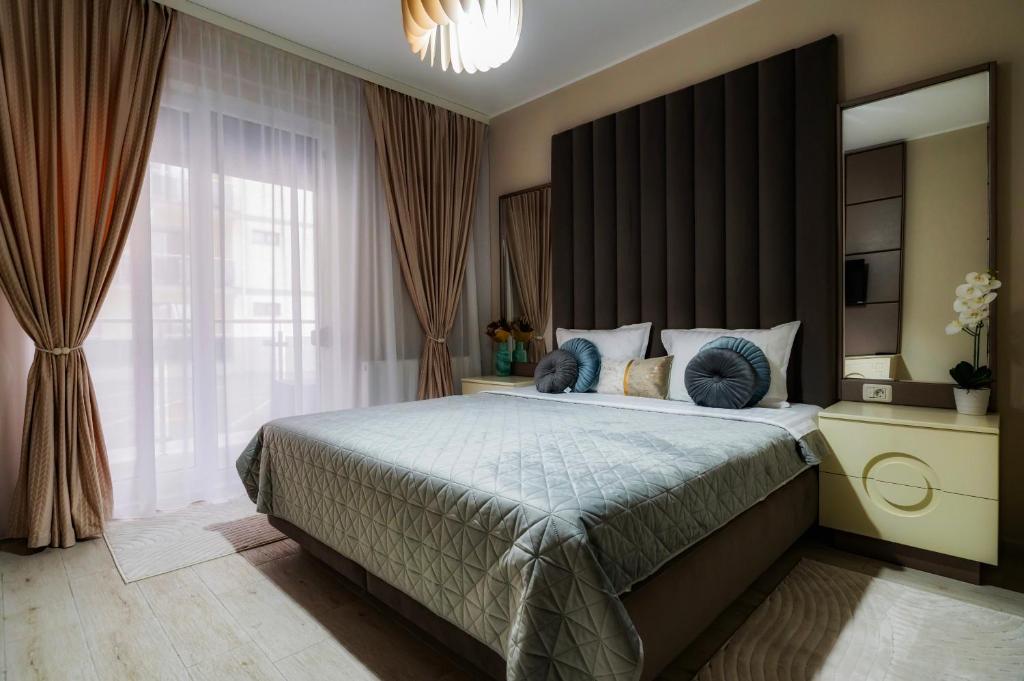 ein Schlafzimmer mit einem großen Bett und einem großen Fenster in der Unterkunft Luna Apartament in Mamaia Nord – Năvodari