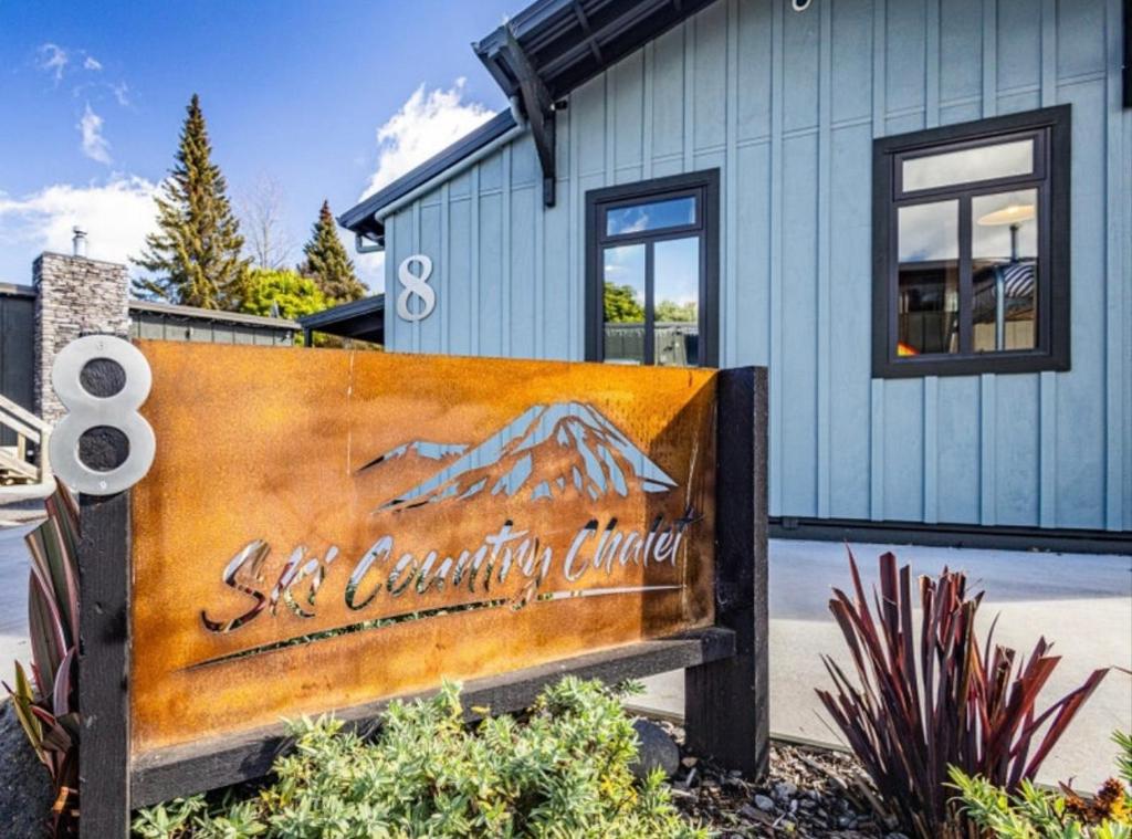 a sign in front of a house with a building at Ski Country Chalet in Ohakune