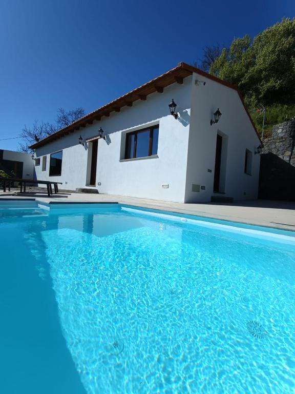 a villa with a swimming pool in front of a house at Natura Luxury in Las Lagunetas