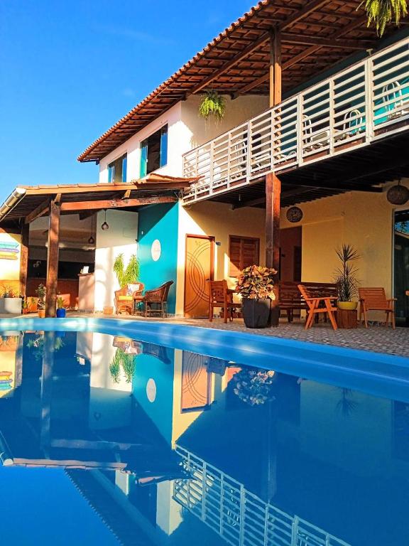 a house with a swimming pool in front of it at Villa Aconchego Guarajuba in Camaçari
