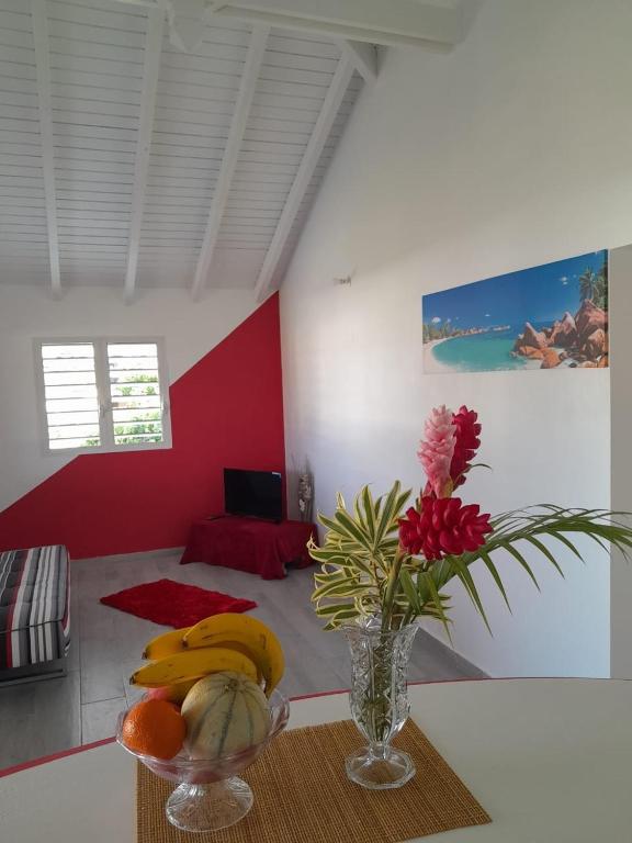 a room with a table with a vase of bananas and flowers at O paradis de Beauplan in Port-Louis